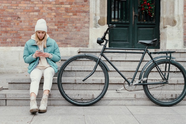 Mulher com sua bicicleta fazendo uma pausa
