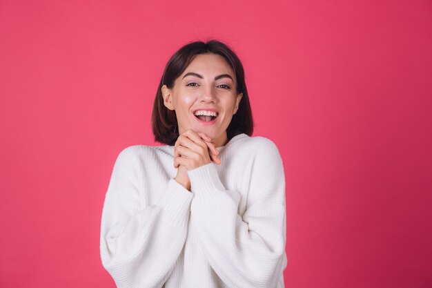 Mulher com suéter branco casual na parede rosa vermelha