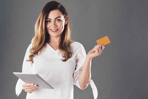 Mulher com tablet e cartão de crédito