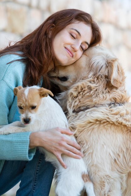 Mulher com tiro médio abraçando cachorros