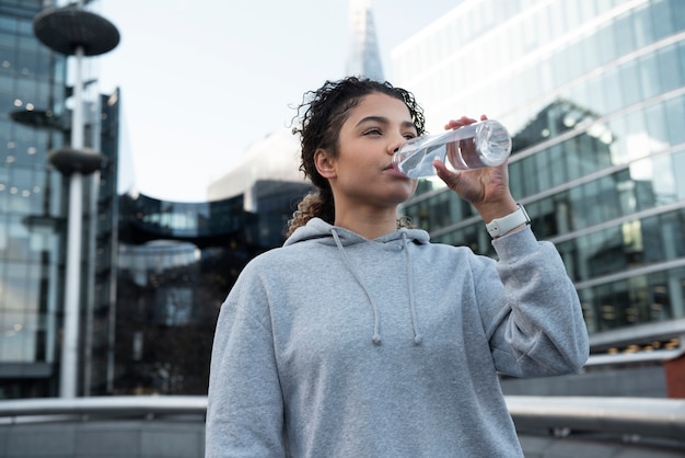 Mulher com tiro médio bebendo água