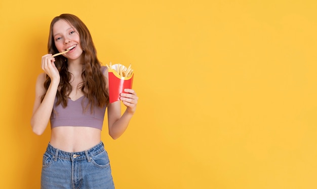 Mulher com tiro médio comendo batatas fritas