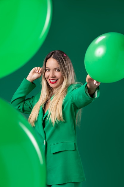 Mulher com tiro médio segurando um balão verde