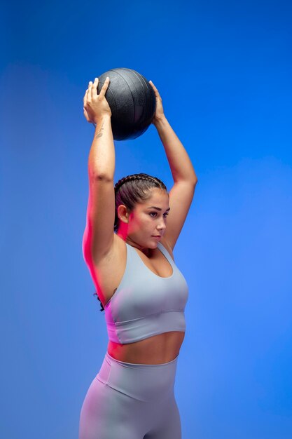 Mulher com tiro médio segurando uma bola