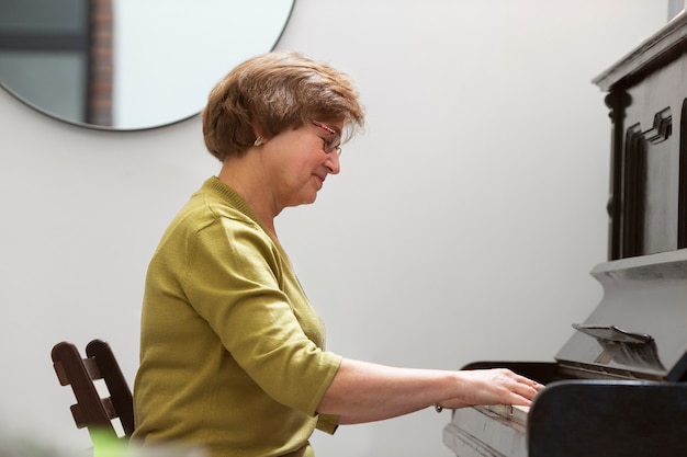 Foto grátis mulher com tiro médio tocando piano
