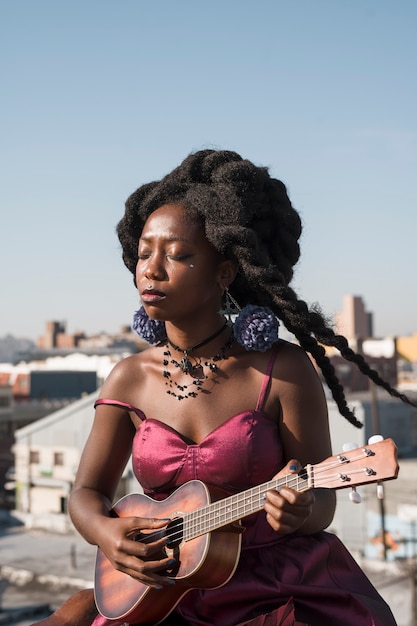 Foto grátis mulher com tiro médio tocando ukulele