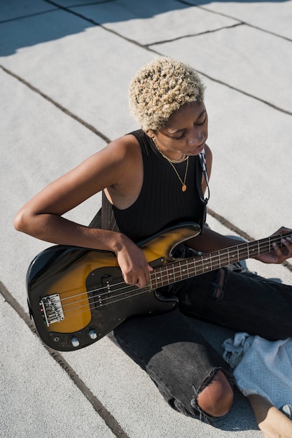 Foto grátis mulher com tiro médio tocando violão