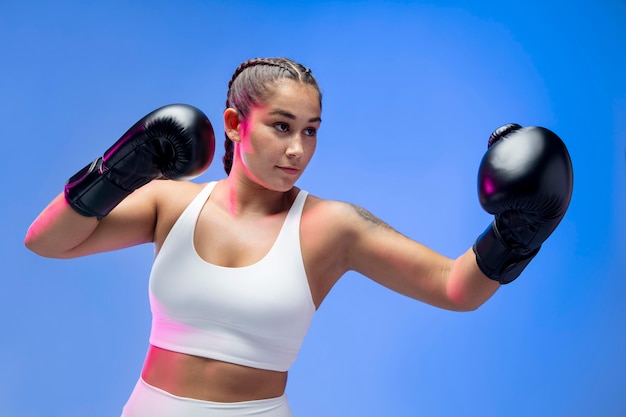 Mulher com tiro médio usando luvas de boxe