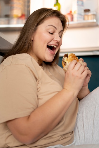 Mulher com transtorno alimentar tentando comer fast food