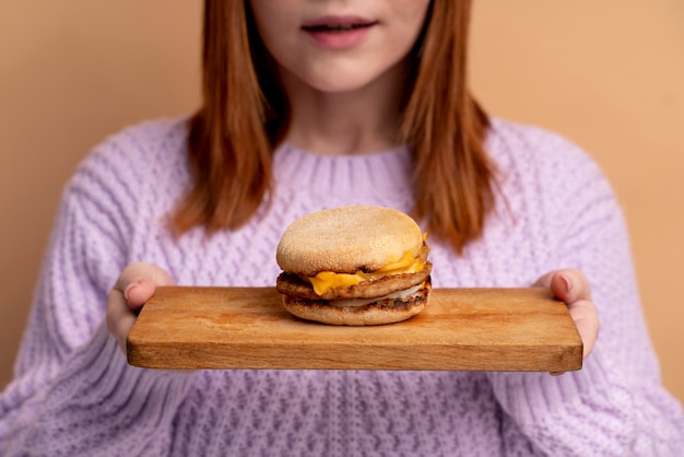 Mulher com transtorno alimentar tentando comer hambúrguer