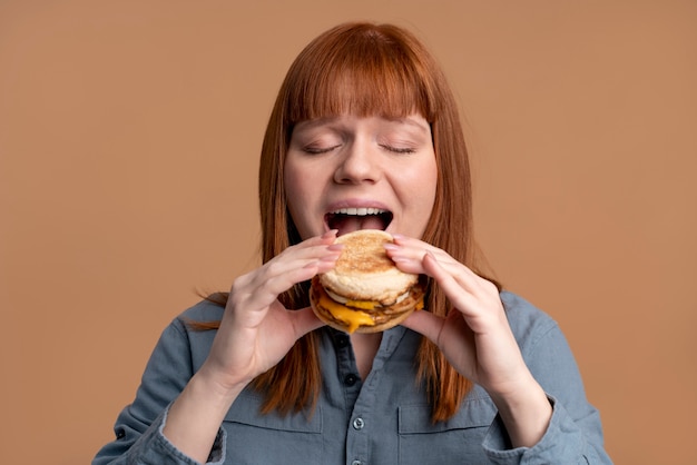 Mulher com transtorno alimentar tentando comer hambúrguer