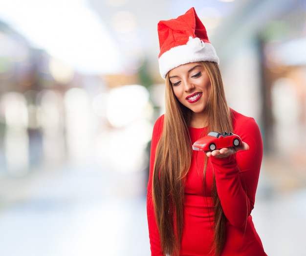 Mulher com um carro de brinquedo em um shopping center