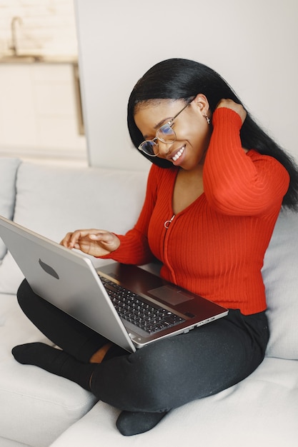 Mulher com um laptop no sofá