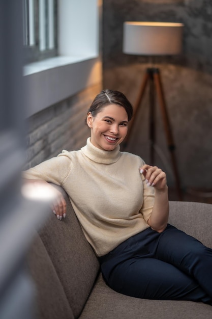 Mulher com um sorriso radiante sentado em uma sala