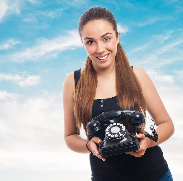 Mulher com um telefone antigo na mão