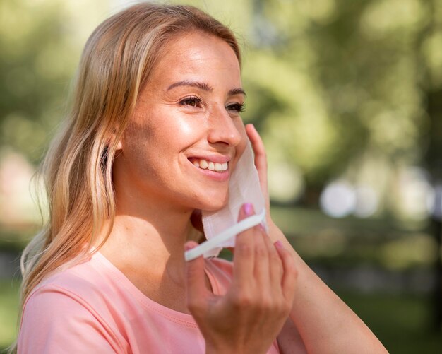 Mulher com uma camiseta rosa usando uma máscara médica