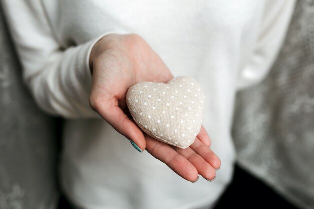 Mulher com uma pedra em forma de coração nas mãos