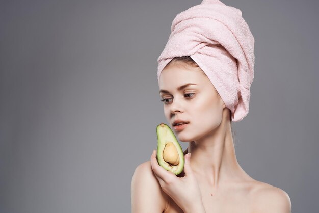 Mulher com uma toalha na cabeça cuidados com a pele abacate posando closeup