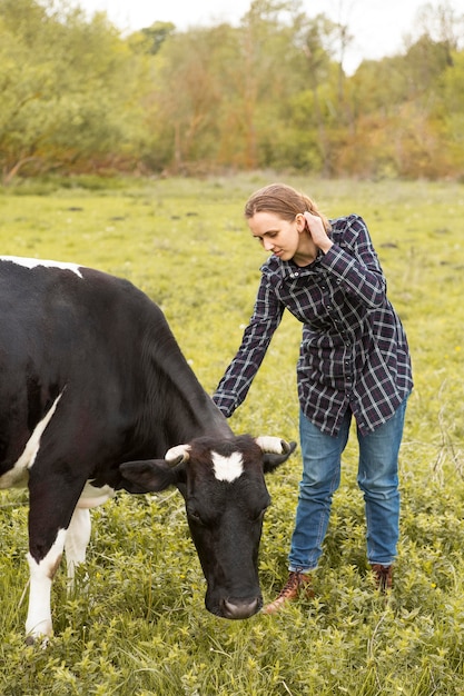 Foto grátis mulher com uma vaca na fazenda