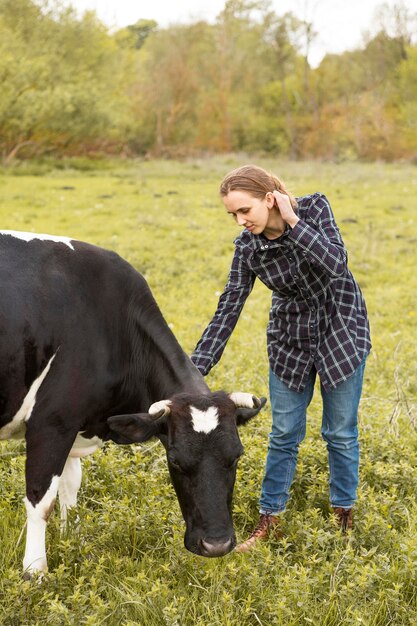 Mulher com uma vaca na fazenda