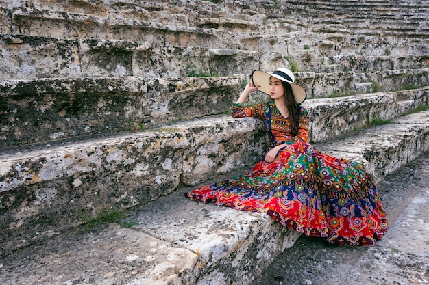 Mulher com vestido boêmio sentado no teatro da antiga cidade de hierápolis em pamukkale, turquia.