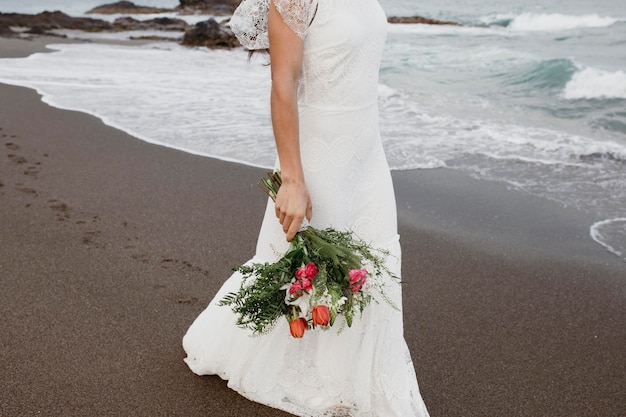 Mulher com vestido de noiva na praia Foto gratuita