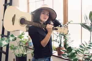 Foto grátis mulher com violão no ombro