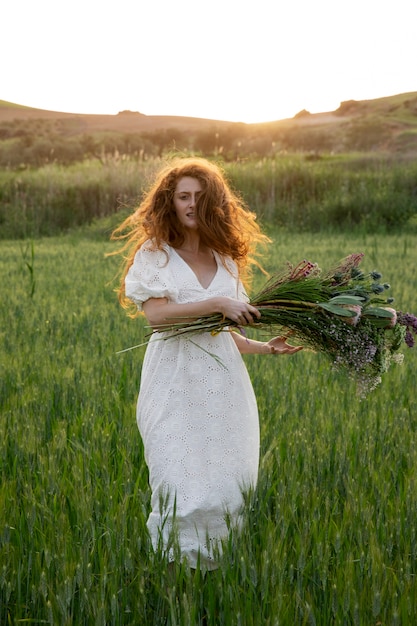 Foto grátis mulher com vista frontal de buquê de flores