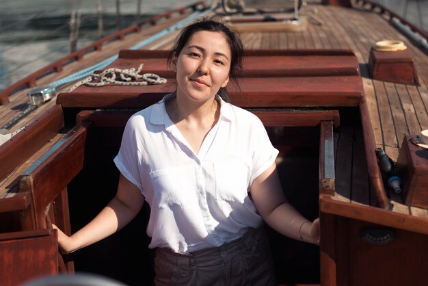 Mulher com vista frontal posando em um barco