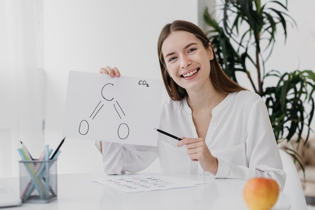 Foto grátis mulher com vista frontal segurando um desenho de química