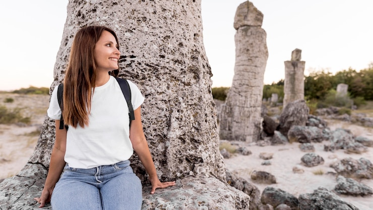 Foto grátis mulher com vista frontal visitando um belo lugar com espaço de cópia