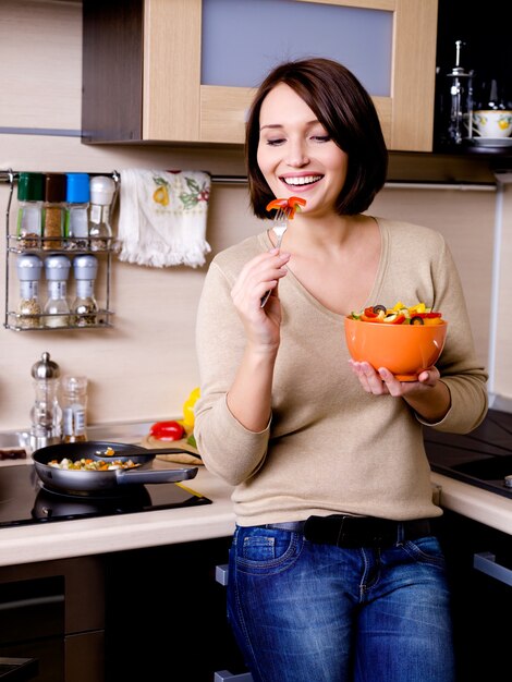 mulher come salada de vegetais