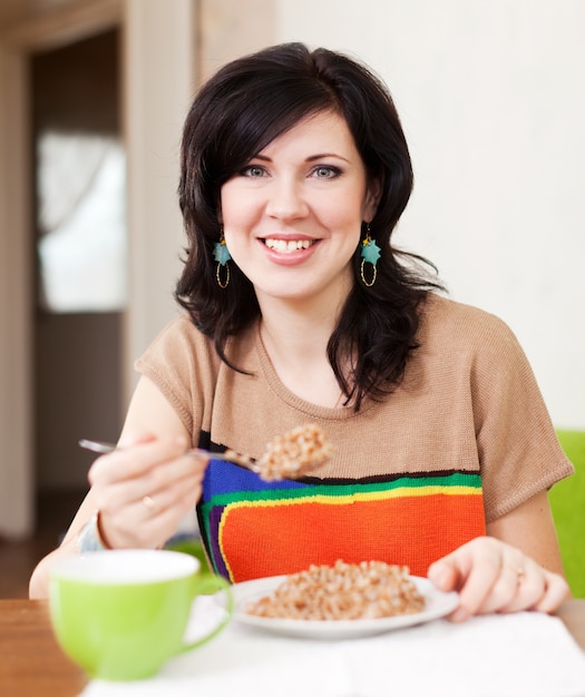 mulher comendo cereal em casa