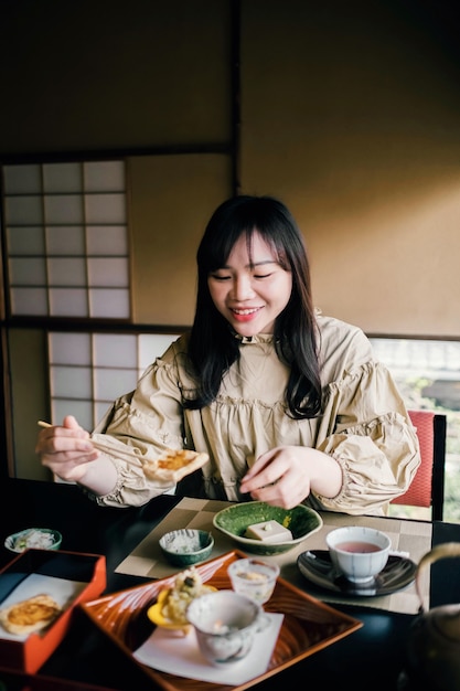 Foto grátis mulher comendo com pauzinhos tiro médio