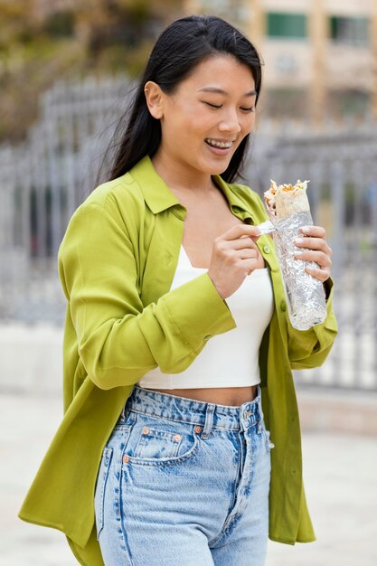 Mulher comendo comida de rua