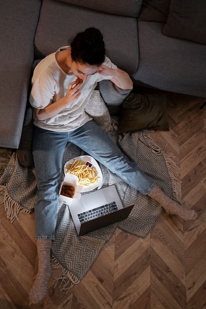 Foto grátis mulher comendo fast food enquanto assiste a um filme