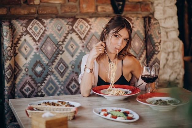 Foto grátis mulher comendo macarrão em restaurante italiano