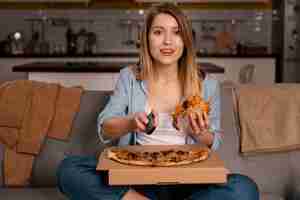 Foto grátis mulher comendo pizza enquanto assiste tv