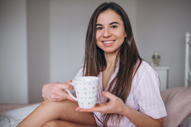 Mulher, comer, delicioso, croissant, com, café cama