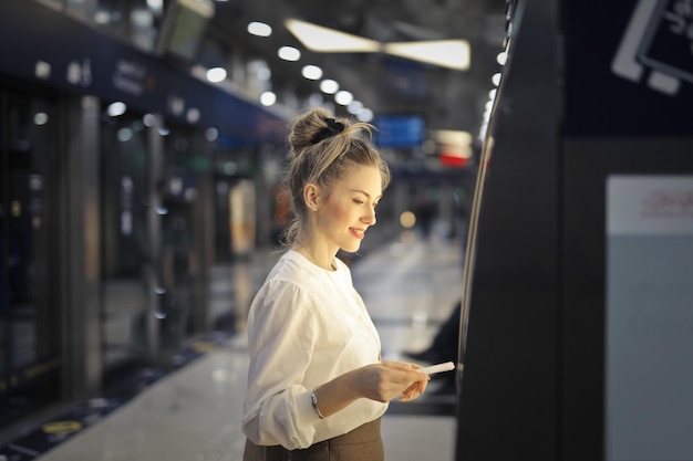 Foto grátis mulher compra uma passagem no metrô