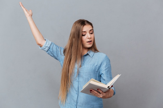 Mulher concentrada ensaia com livro na mão