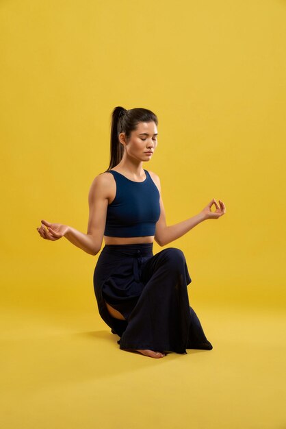 Mulher concentrada fazendo equilíbrio de yoga asana dentro