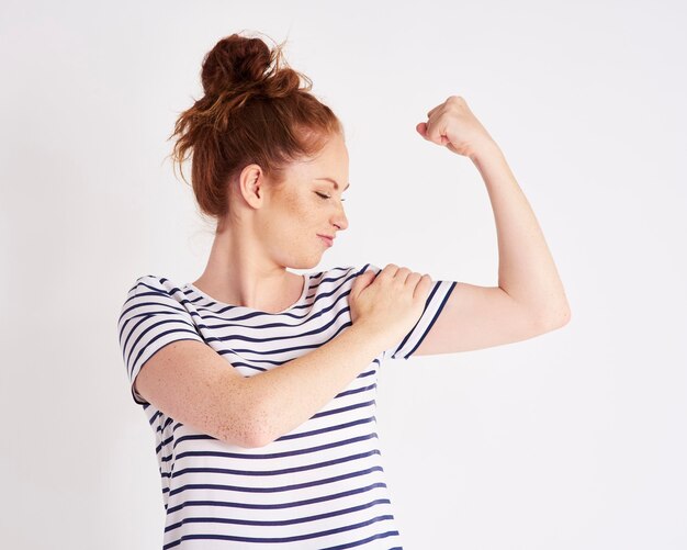 Mulher confiante e forte mostrando sua tacada de bíceps