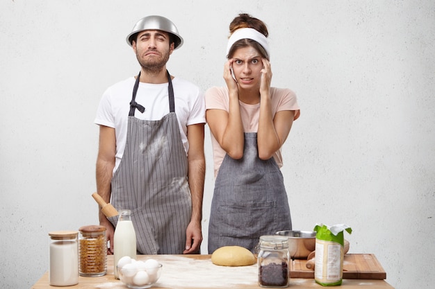 Foto grátis mulher confusa mantém as mãos nas têmporas, tenta se lembrar da receita,