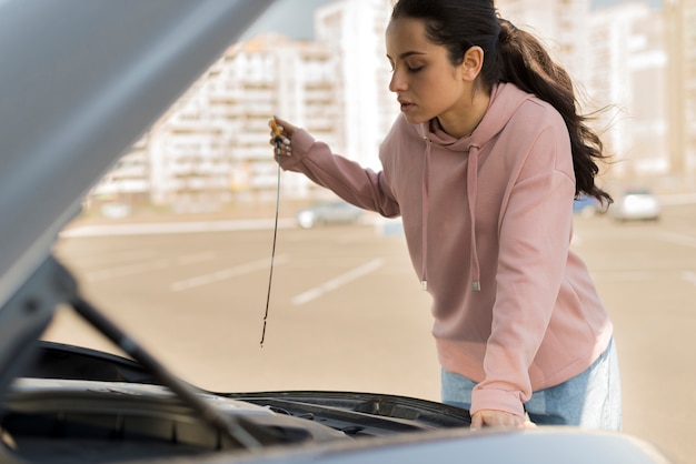 Foto grátis mulher consertando seu carro nas proximidades da cidade