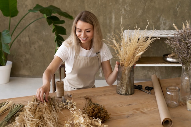 Mulher construindo seu próprio arranjo de flores secas