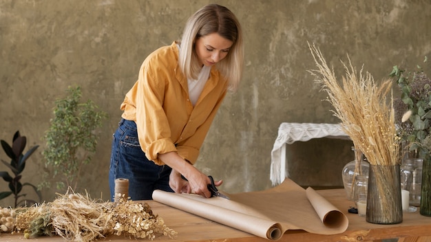 Foto grátis mulher construindo seu próprio arranjo de flores secas