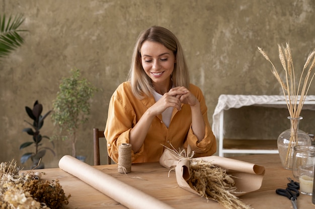 Foto grátis mulher construindo seu próprio arranjo de flores secas