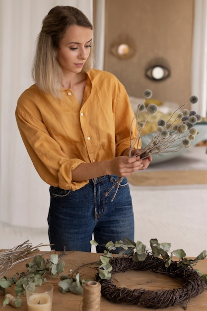 Foto grátis mulher construindo seu próprio arranjo de flores secas