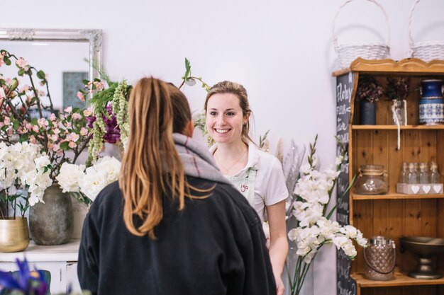 Mulher conversando com florista na loja